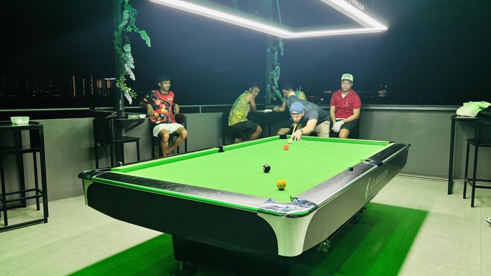 People relaxing on the edge in front of billard table at Greys Rooftopbar