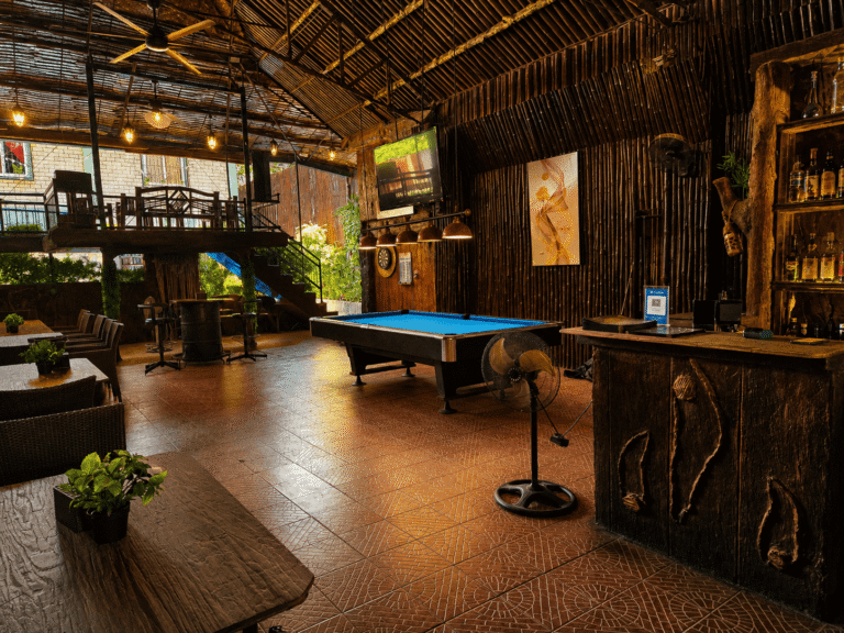 Inside cozy dark bar with wooden panels and pool table